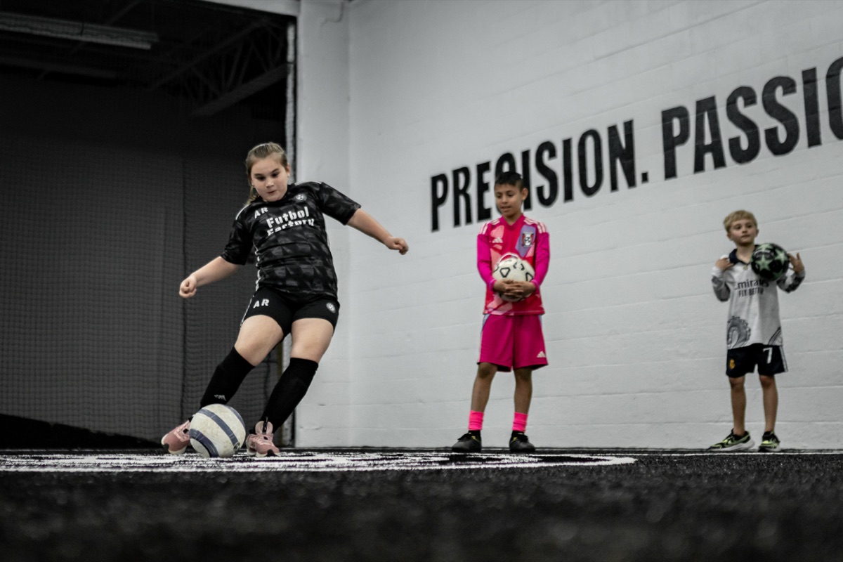 A Futbol Factory player striking a ball